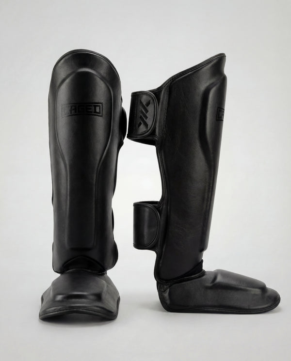 Espinilleras Caged 'X' Series – Negro/Negro