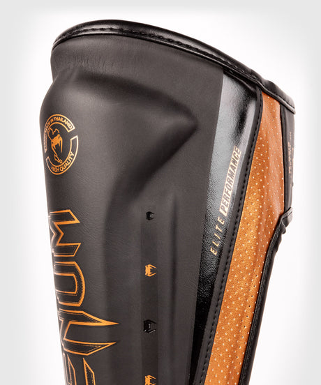 Espinilleras Venum Elite Evo – Negro/Bronce