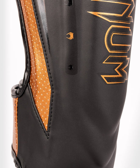 Espinilleras Venum Elite Evo – Negro/Bronce