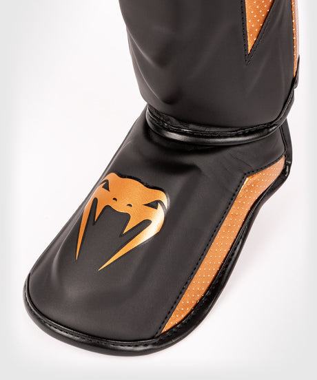 Espinilleras Venum Elite Evo – Negro/Bronce