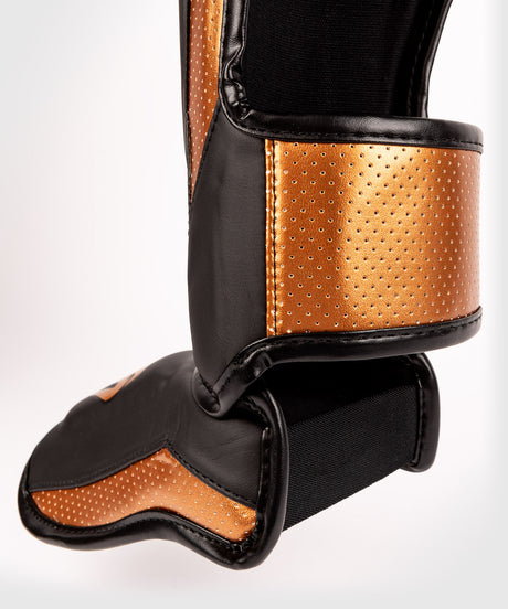 Espinilleras Venum Elite Evo – Negro/Bronce